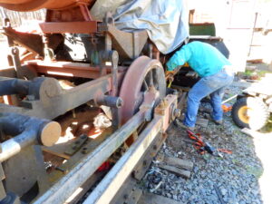 Image of volunteers working on steam engine wheel set